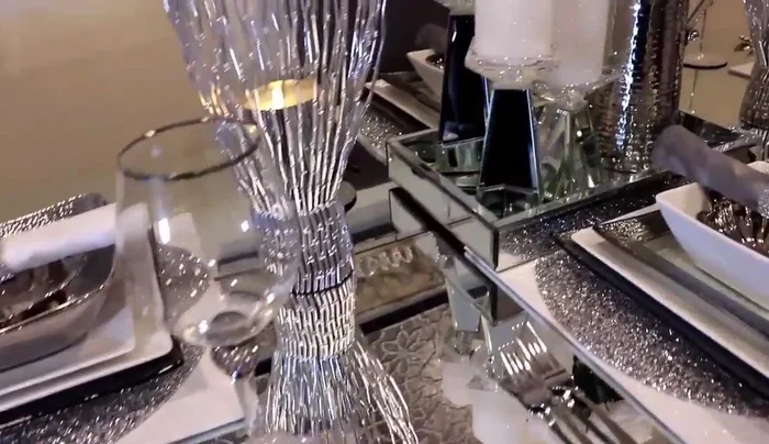 Arrange the mirror pillow candle holders, silver picture frame, and silver vases around the mirror tray.