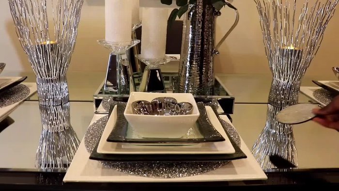 Gather all necessary items: rhinestone butterfly brooches, rhinestone flatbacks, roses, placemats, plates, bows, goblets, mirror tray, candle holders, picture frame, vases, and coasters.