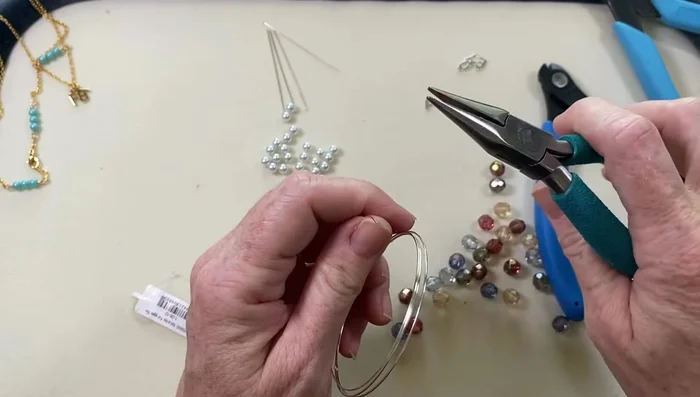 Create a loop at one end of the memory wire using chain nose pliers to act as a bead stopper.