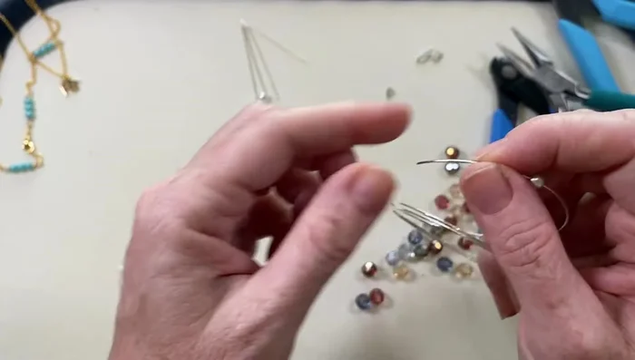 Add beads to the wire, following a desired pattern. The video uses a pattern of two check glass beads and one pearl.