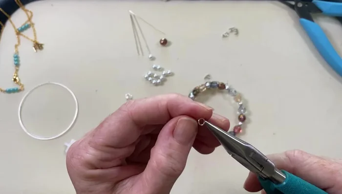 Attach the alphabet charm to the bracelet using a jump ring.