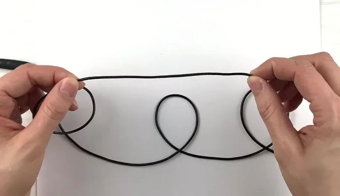 After the three loops, bring the cord down through the main loop, creating a slip knot.