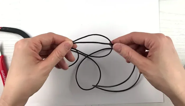 After the three loops, bring the cord down through the main loop, creating a slip knot.