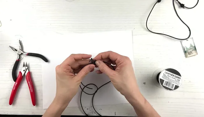 After the three loops, bring the cord down through the main loop, creating a slip knot.