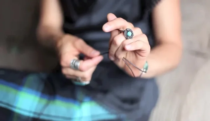 Adjust the fit: Hold the larger knot with your fingers and pull the long cord to tighten the bracelet around your wrist. Adjust until comfortable.