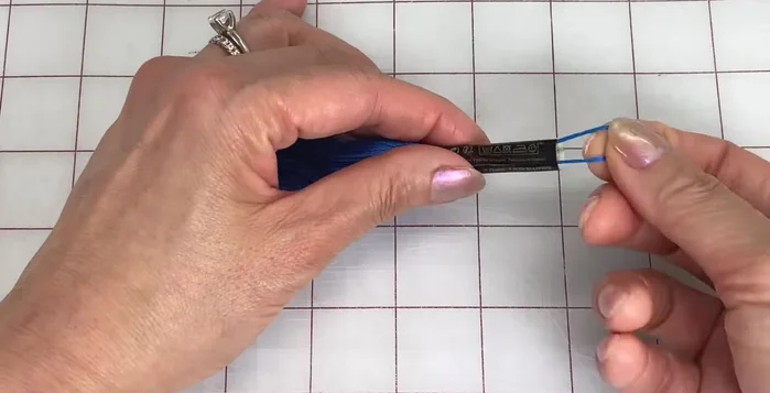 Thread the end through the loop and pull the top strand to close it up. Remove the sleeve and pull on the top strand until the loop disappears.