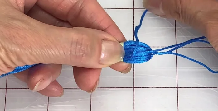 Thread the end through the loop and pull the top strand to close it up. Remove the sleeve and pull on the top strand until the loop disappears.