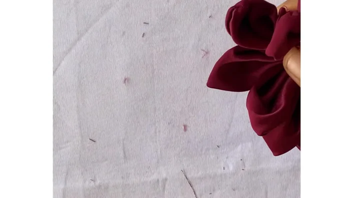 Thread a needle and pass it through the first petal, pulling it through to join the circle and secure it. Arrange the petals well before pulling tight.