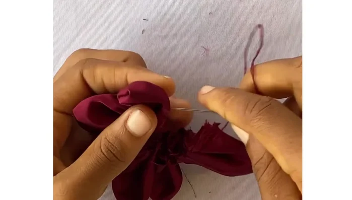 Thread a needle and pass it through the first petal, pulling it through to join the circle and secure it. Arrange the petals well before pulling tight.