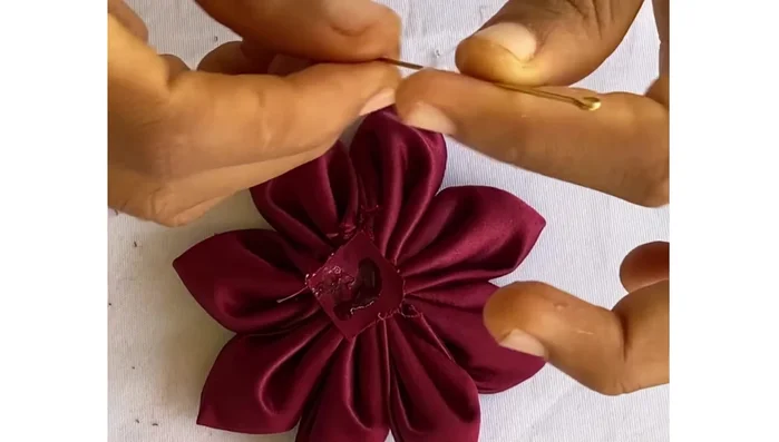 Glue the pin to the back of the flower. Cover the pin with another small piece of fabric (or felt) to conceal it, securing it with glue.