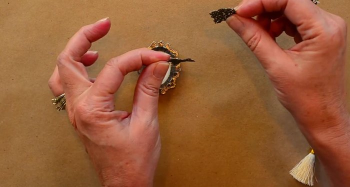 Attach metal filigrees to the back of the brooch using glue to create loops for attaching jump rings. Allow glue to dry completely (15 minutes).