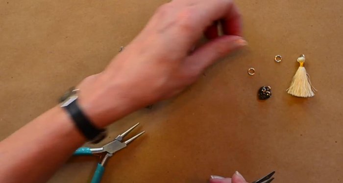 Open jump rings using two pairs of pliers (one holding, one twisting). Attach one end of the jump ring to the lower filigree and the other end to a charm (heart, etc.). Close the jump ring.