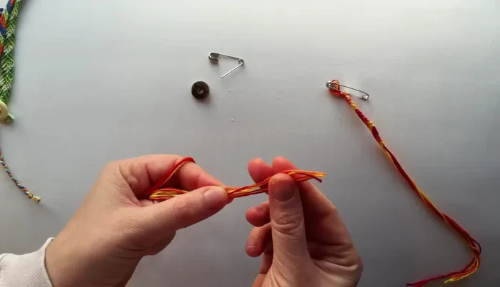 Arrange your floss: Arrange the three strands neatly. The order doesn't matter initially.