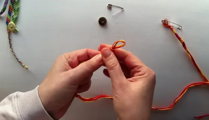 Arrange your floss: Arrange the three strands neatly. The order doesn't matter initially.