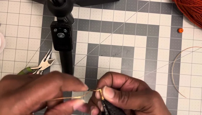 Once you reach the tip, create a small loop at the end for your jump ring. Secure the loop by wrapping the wire around several times, then snip the excess wire.