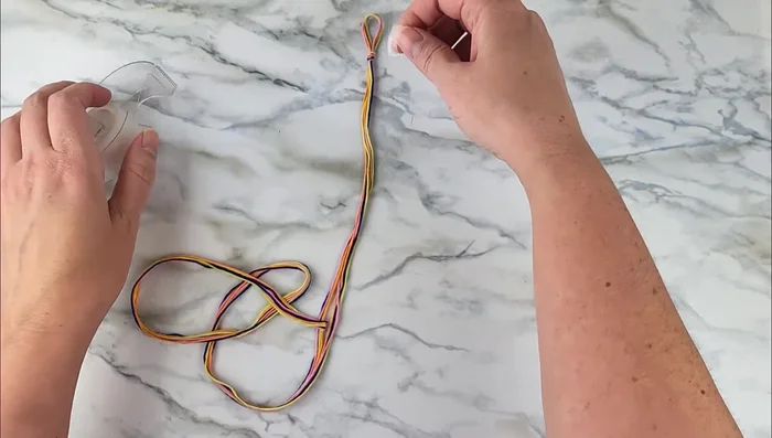 Tape or pin the loop to a flat surface to keep it stable.