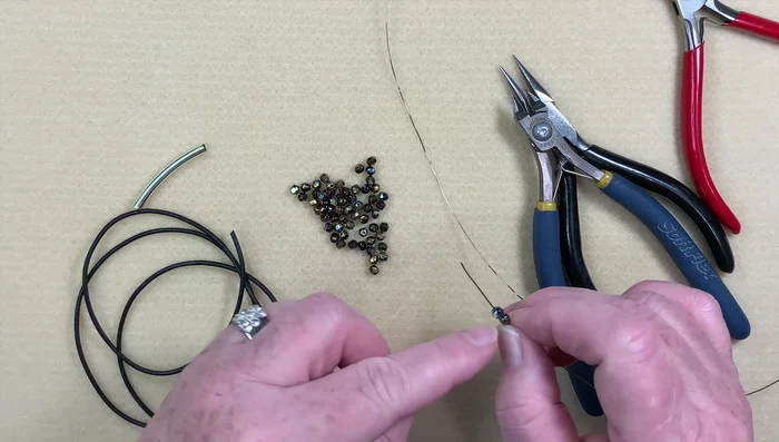 Repeat wrapping: Continue wrapping the wire around the tube, pushing down beads as you go until all beads are on the wire.