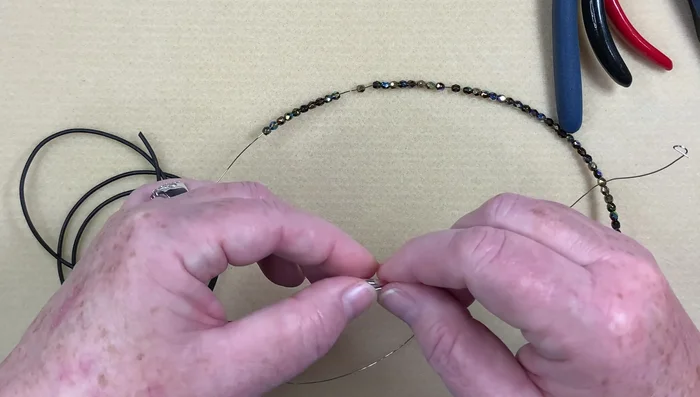 Repeat wrapping: Continue wrapping the wire around the tube, pushing down beads as you go until all beads are on the wire.