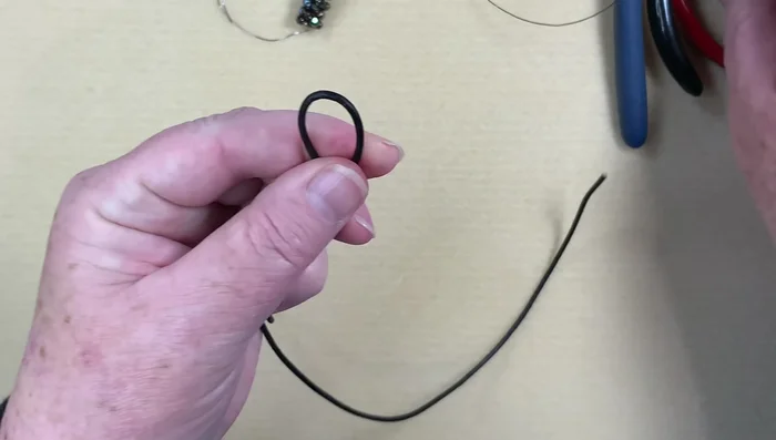 Prepare the leather: Cut and fold the leather cord in half.