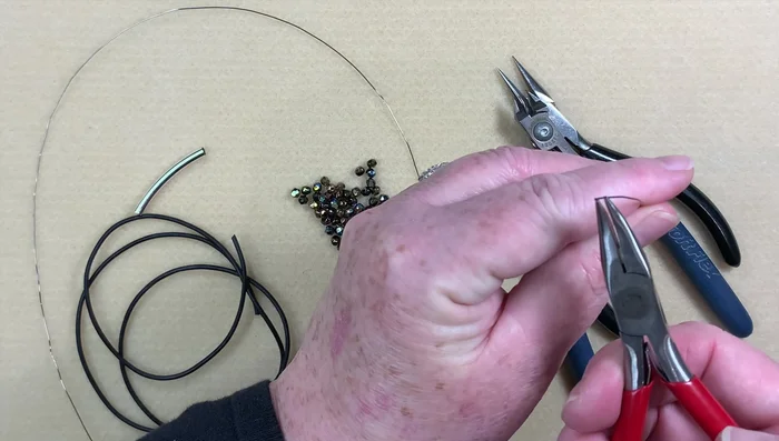 Prepare the leather: Cut and fold the leather cord in half.