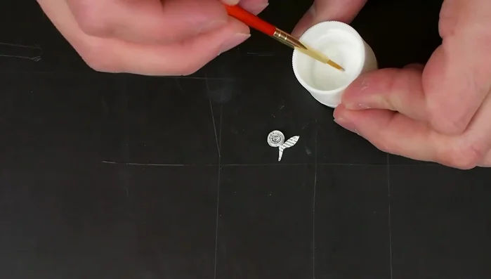 Seal the paper flower with Mod Podge to prevent staining during resin embedding (apply about four coats).