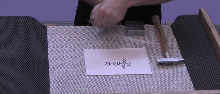 Make the initial spiral at the top of the pin stem. Use round-nose pliers to help shape the spiral. Lock in the spiral by hammering it against a bench block.