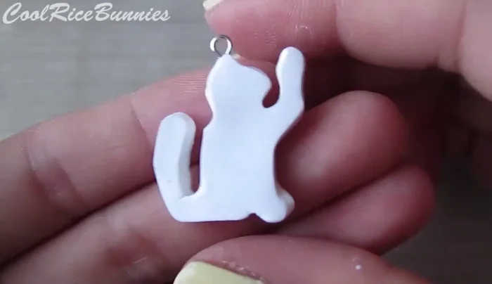 Add eyepins: Insert an eye pin into the top of the cat and the bottom of the yarn balls.