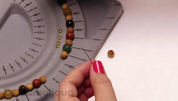 Add beads to one side until reaching the desired length. Add a bead stopper to this end.