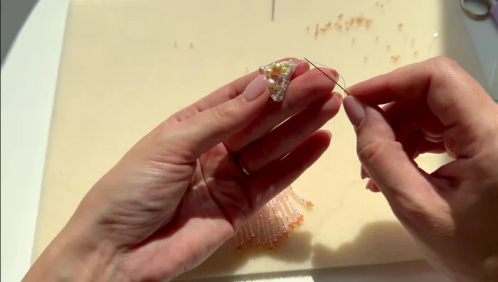 Attach the fringe strands to the back of the earring, securing the thread carefully to prevent it from being visible.