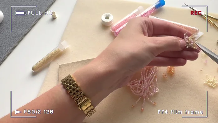 Embroider the felt triangle with larger crystals and seed beads. Fill in gaps with smaller beads to cover the felt completely.