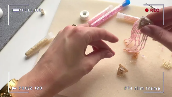 Embroider the felt triangle with larger crystals and seed beads. Fill in gaps with smaller beads to cover the felt completely.