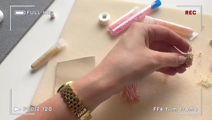 Embroider the felt triangle with larger crystals and seed beads. Fill in gaps with smaller beads to cover the felt completely.