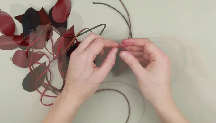 Thread a cord through the rings, ensuring leaves of similar shades are on the same cord.