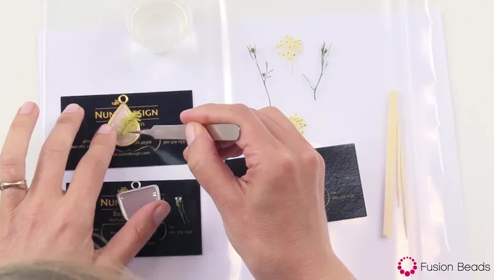 Add more clear resin to cover the organics completely. If resin spills over the sides, use a toothpick or intentionally pour more resin to the sides and create a consistent, even dome.