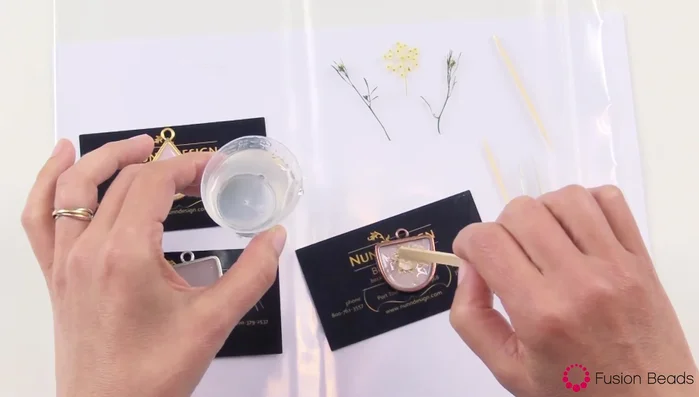 Add more clear resin to cover the organics completely. If resin spills over the sides, use a toothpick or intentionally pour more resin to the sides and create a consistent, even dome.