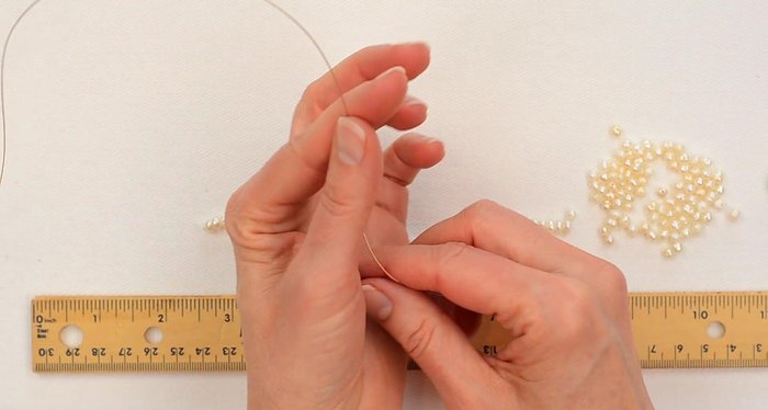 Cut an 18-inch piece of bead stringing wire and tape one end to prevent beads from sliding off.