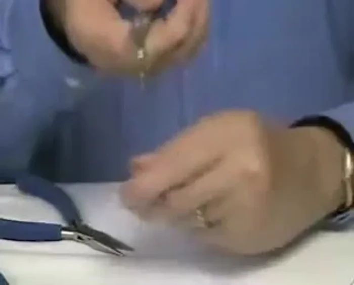 Rest the pin at the top of the bend and bend it all the way back over the wire of the pliers.