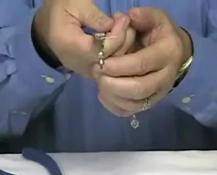 Rest the pin at the top of the bend and bend it all the way back over the wire of the pliers.