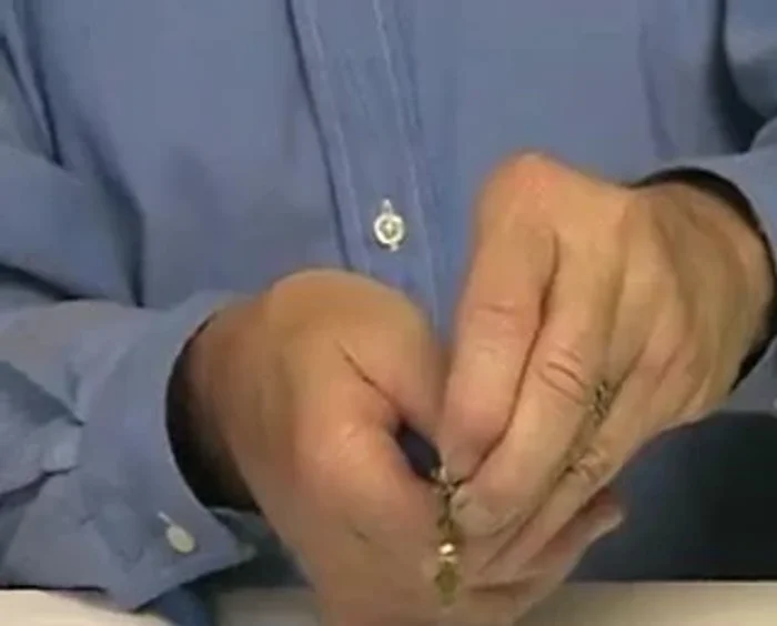 Close the loop by bending the top with your pliers, holding it tight while transferring it to another hand. Use your active hand to bend the wire, making two or three loops.