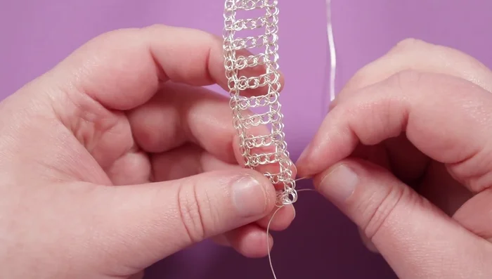 Add beads to the rows inside the frame, ensuring the beads sit tightly and sideways on the loops.