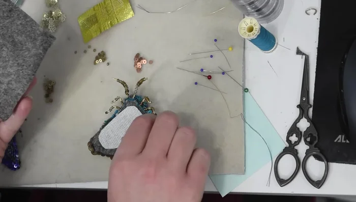 Add a final felt backing, cutting slits for pin, and securing edges with blanket stitch.