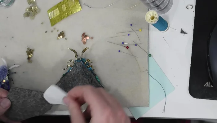 Add a final felt backing, cutting slits for pin, and securing edges with blanket stitch.