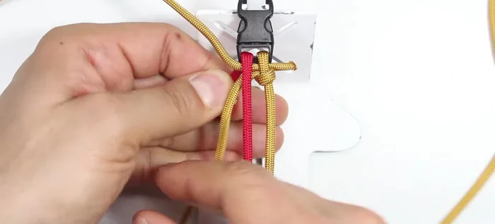 Secure the red cord: Pass the red cord from the top through the middle and through the loop on the left side.