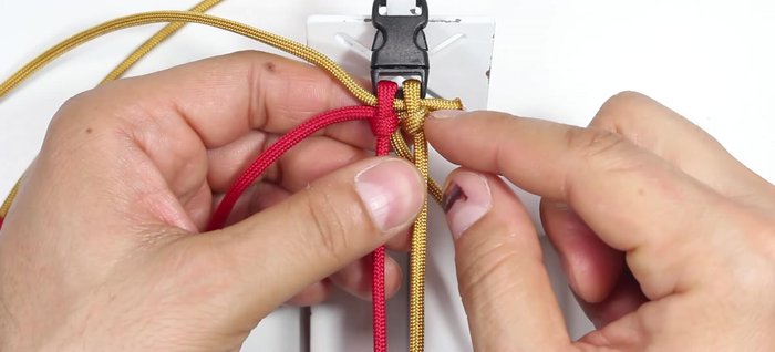 Continue knotting: Alternate between gold and red cords, creating loops and passing them through the previous loops. The goal is to have both gold and red cords heading to the left.