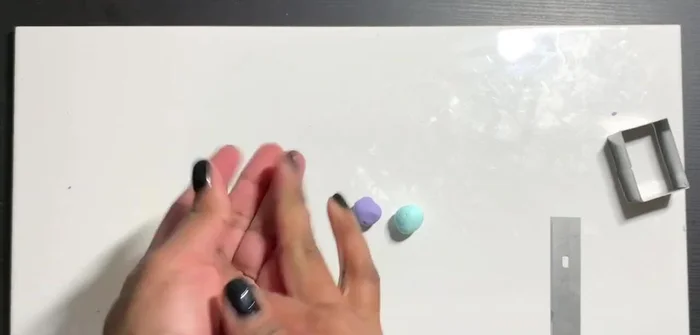 Fold the clay in half, push the sides in, and repeat to stretch lengthwise, adding translucent backing for more pieces.