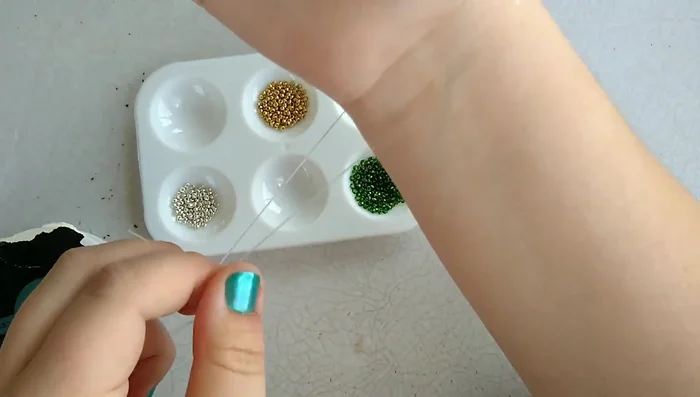 Attach clips to the ends of the string to hold the beads while stringing.