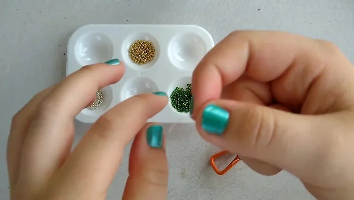 String the beads onto the elastic, following your chosen pattern. Use a needle if necessary, or string directly onto the elastic if it's stiff enough. A time-lapse is shown in the video for this step.