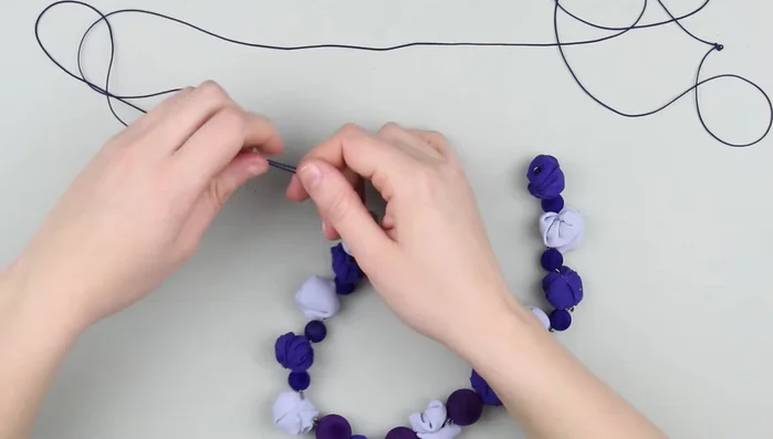 Thread the string through small plastic beads, securing each with knots.