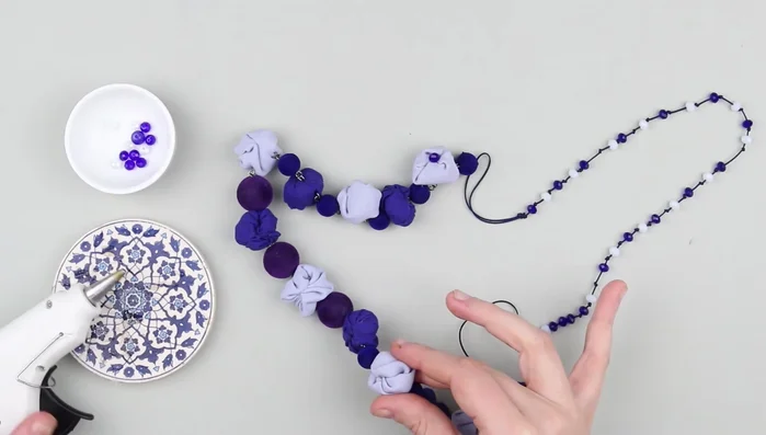 Decorate fabric elements with plastic beads using hot glue.