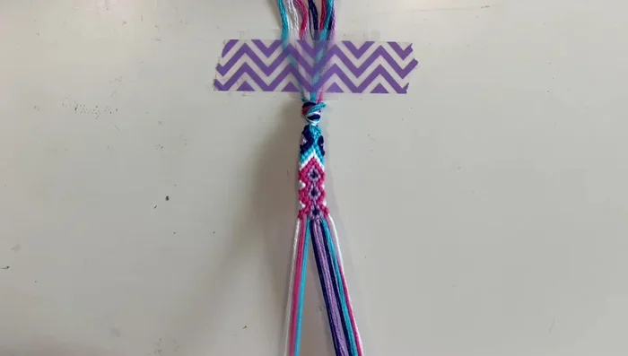 Chevron pattern: Create chevron patterns using forward and backward knots with the pink and white strings.